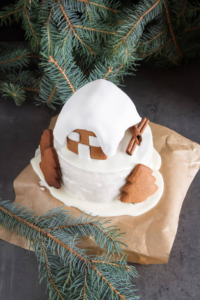 New Year cake with Christmas trees and gingerbread houses and cinnamon. Dark background.
