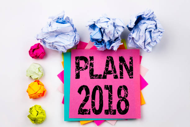 istock Writing text showing Plan 2018 written on sticky note in office with screw paper balls. Business concept for Strategy Action Plan 2018 on the white isolated background. 878718666
