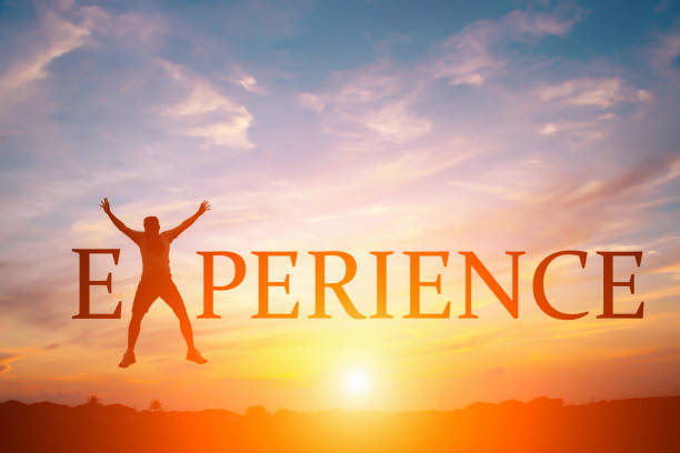 istock Silhouette of happy people and text EXPERIENCE in sunset background 878728136