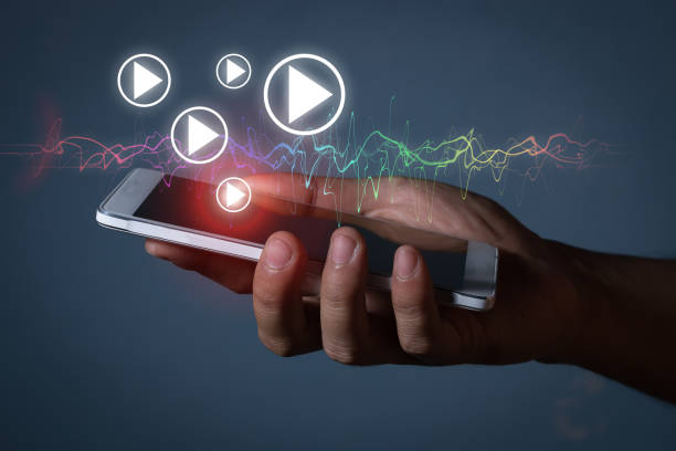 istock hand hold smartphone with play icon and soundwave 878728150