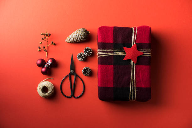 Black and red checkered gift box flat lay on red background