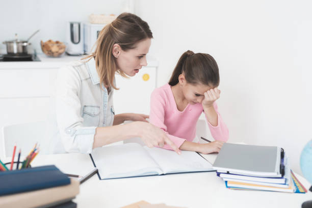 istock Mom helps my daughter do her homework in the kitchen. 878736850