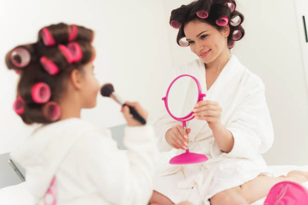 istock Mom teaches a little daughter to do makeup. 878756920