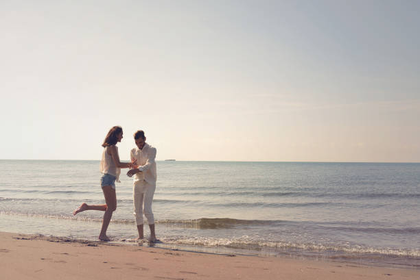 istock Young couple having fun on a sandy coast 878756924