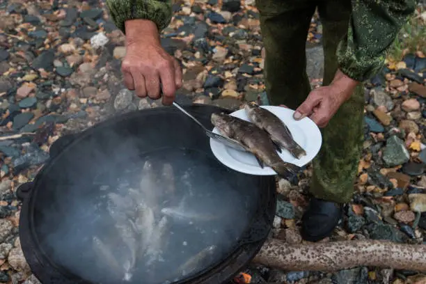 delicious fresh-soup from fish cooked in the metal pot at outdoors