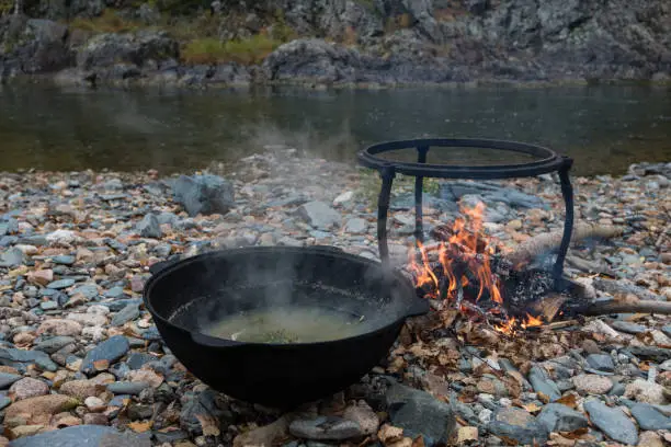 delicious fresh-soup from fish cooked in the metal pot at outdoors