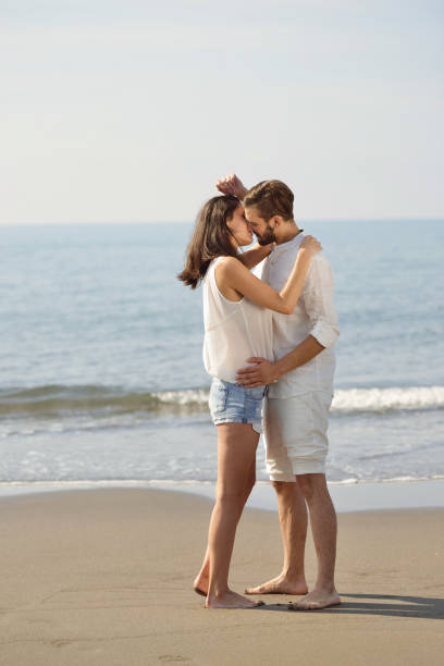 istock Romantic young couple on the beach kissing. 878768970