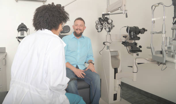 istock Man getting eye test by female optometrist 878776250