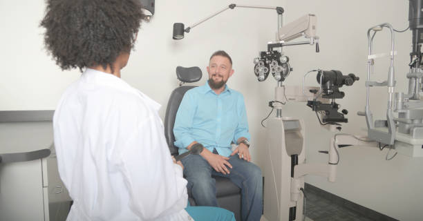 istock Man getting eye test by female optometrist 878776252