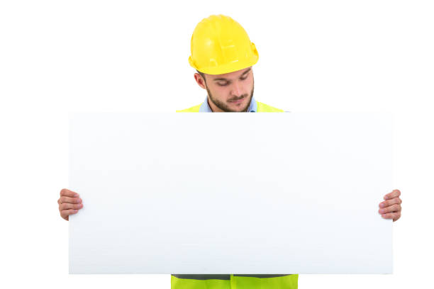 istock Happy male engineer holding an advertisement blank banner. Isolated on white background 878786790