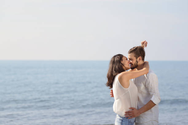 istock Romantic young couple on the beach kissing. 878793544