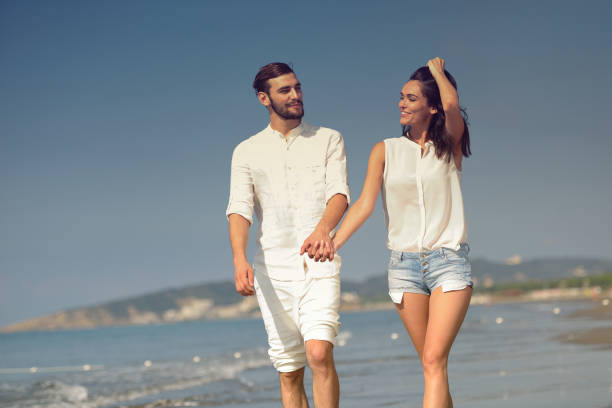 istock Young happy couple on white beach at summer vacation 878800362