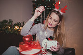 Young woman enjoying christmas and opening presents