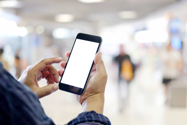 istock Man using smartphone in shopping mall space background and copy space. Blank screen for graphics display montage. 878803654