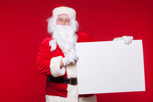 istock Santa Claus pointing in blank advertisement banner isolated on red background with copy space 878806194
