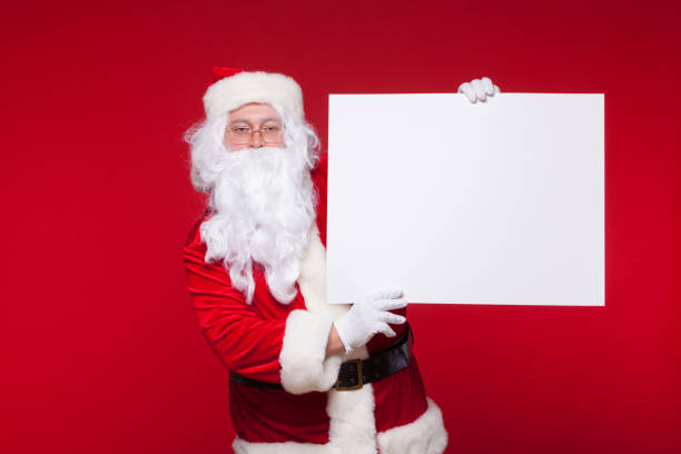 istock Santa Claus pointing in blank advertisement banner isolated on red background with copy space 878806222