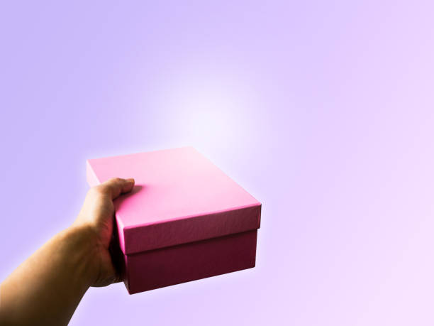istock Pink box and hand holding on pink pastel background with copy space 878812108