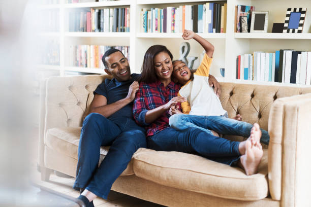 istock Parents with cheerful daughter at home 878837610