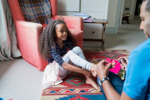 istock Father applying nail polish on daughter's toenail 878840474