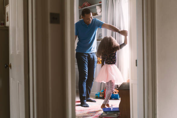 Happy father dancing with daughter in bedroom Happy father and girl dancing in bedroom. Cheerful man and daughter are enjoying at home. They are spending leisure time. dancing dad stock pictures, royalty-free photos & images