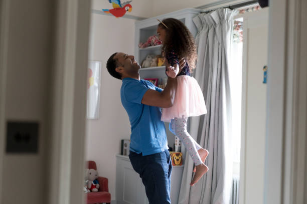 istock Playful father picking daughter in bedroom 878840752