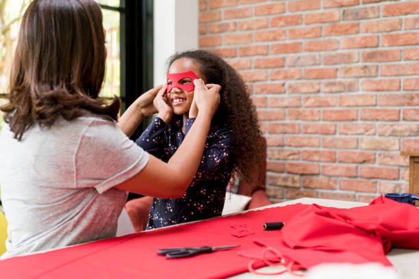 istock Woman holding eye mask on smiling daughter's face 878841324
