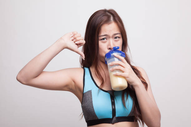 istock Beautiful Asian healthy girl thumbs down hate whey protein. 878843832