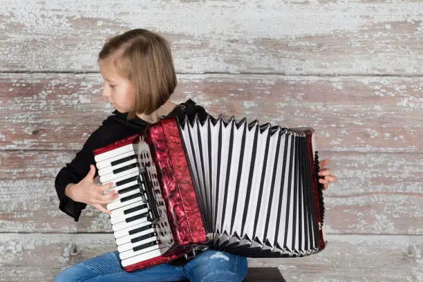Girl focusing on playing an accordion