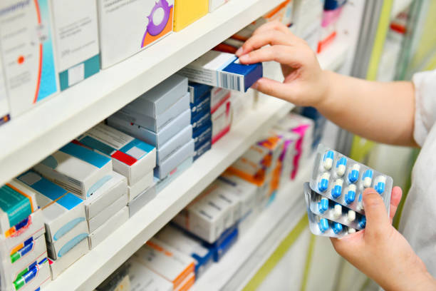 Pharmacist holding medicine box and capsule pack stock photo