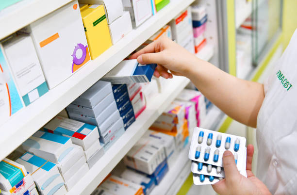istock Pharmacist holding medicine box and capsule pack 878854896