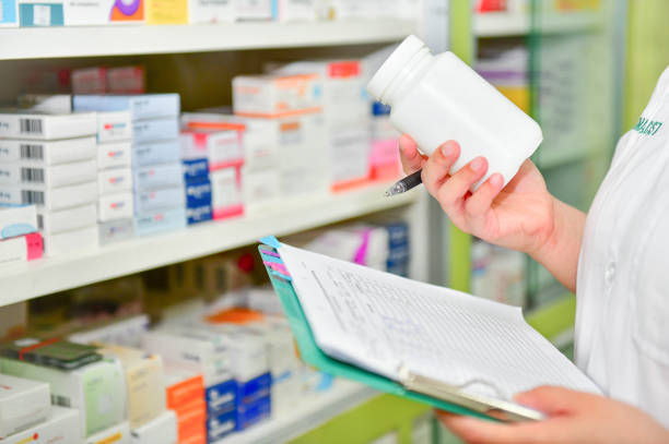 istock Pharmacist holding medicine bottle and prescription chart 878855074