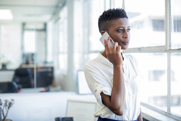 istock Businesswoman using smart phone by office window 878855300