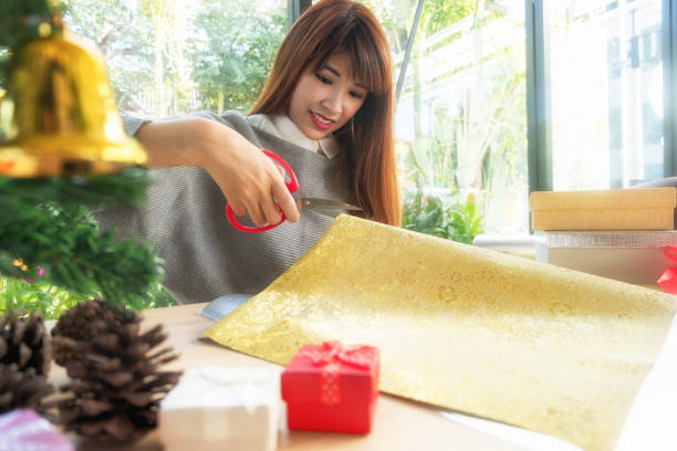 istock woman wearing santa hat packaging christmas gift 878859722