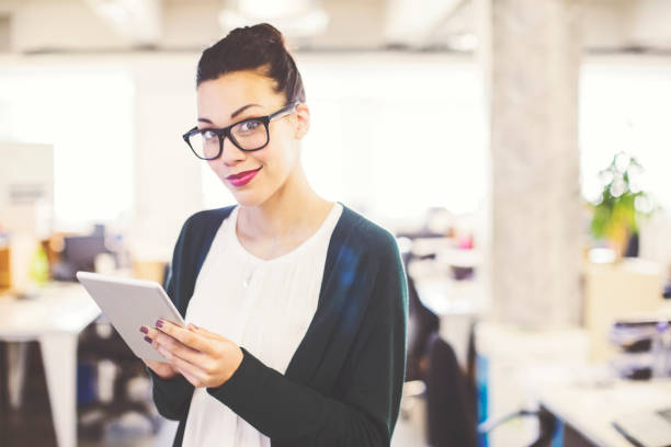 istock Young businesswoman using tablet pc in office 878859856
