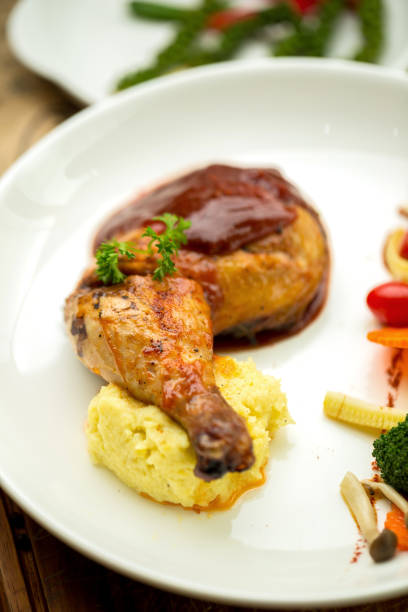 istock Grilled chicken legs and vegetables in white dish isolated on white plate 878859914