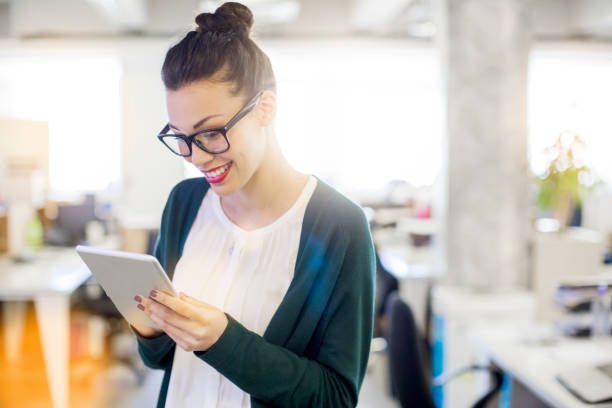 istock Young businesswoman using tablet pc in office 878859952