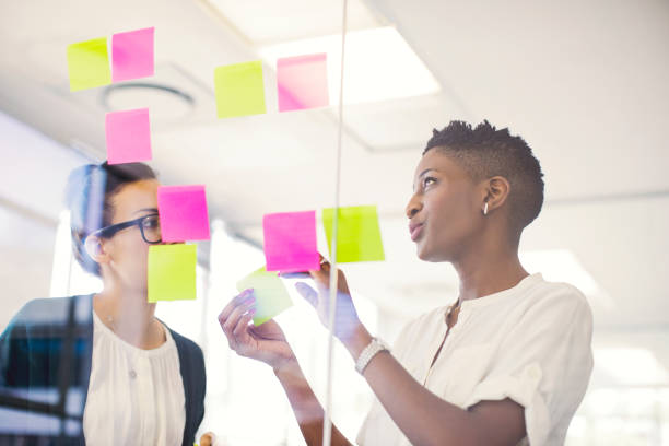 istock Businesswomen discussing over adhesive notes 878859996