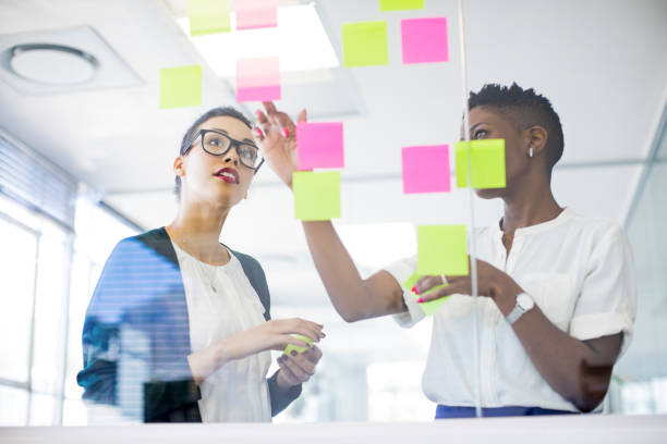istock Businesswomen discussing over sticky notes 878860114