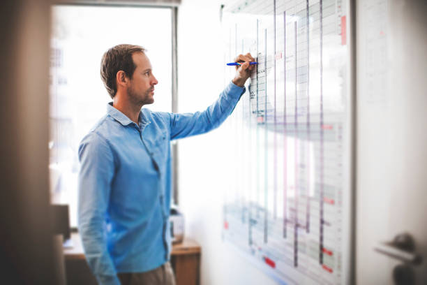 istock Businessman writing on whiteboard in office 878862850