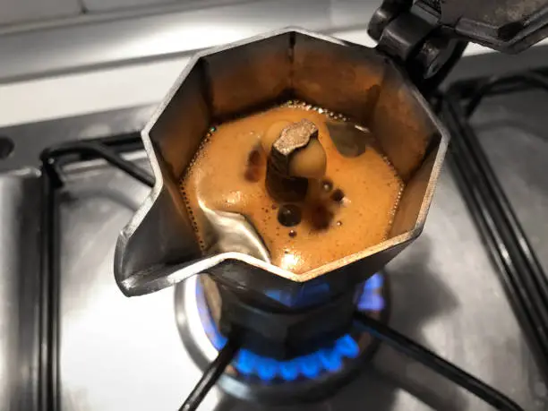 Photo of Moka with coffee on the stove top. Traditional italian coffee maker.