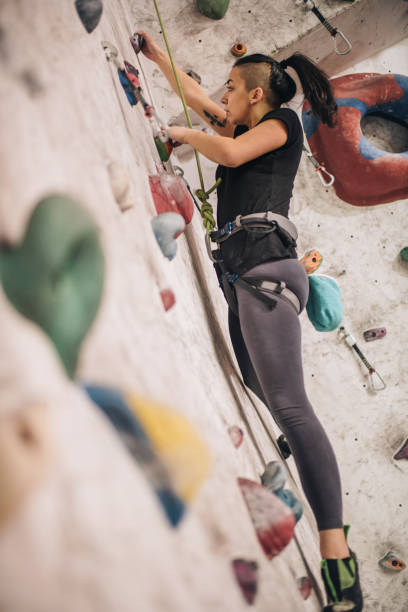 istock Female athlete practicing climbing on a wall in bouldering gym. 878863670