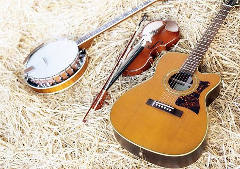 Banjo, guitarra acústica y violín en la paja photo