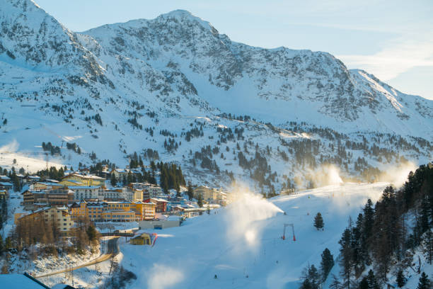 4 estaciones - invierno, comenzando con el trabajo de cañones de nieve en esquí - ski resort austria village winter fotografías e imágenes de stock