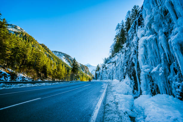 istock Car Trip - many icicles along road in mountains on winter day 878884896