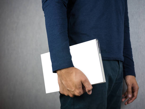 istock Man holding empty book cover with copy space, close up 878885030