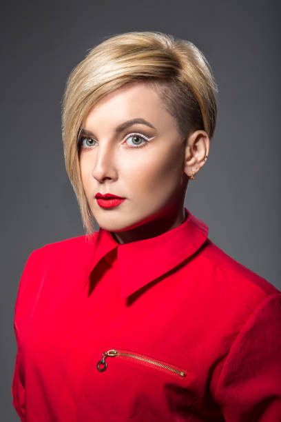 Beautiful woman in red with short haircut Beautiful woman in red with short haircut half shaved hairstyle stock pictures, royalty-free photos & images