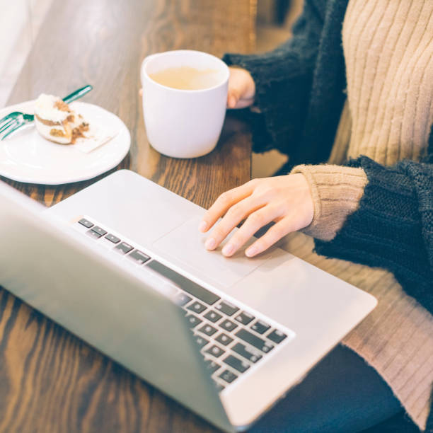 istock Young woman working with laptop in cafe,partial view 878894178