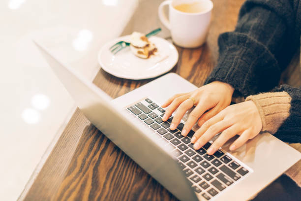 istock Young woman working with laptop in cafe,partial view 878894282