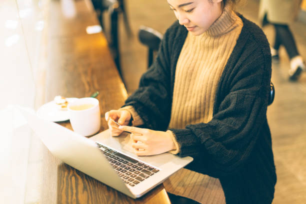 istock young woman using credit card and laptop in cafe 878894770