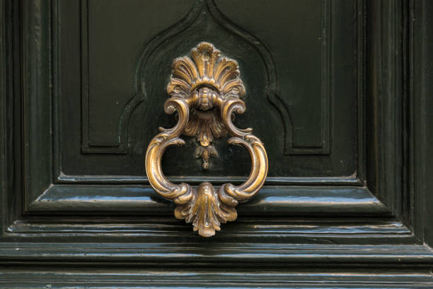 istock Old metal door handle knocker on a wooden background 878902332